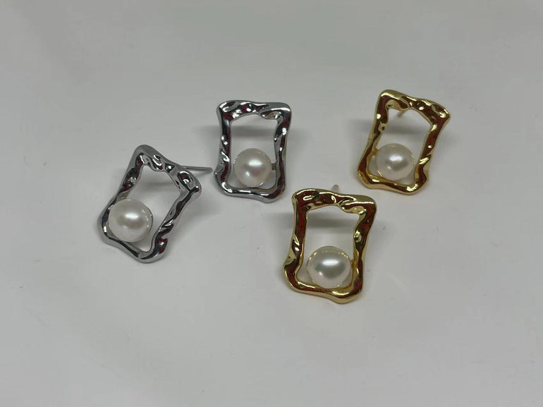 Four stud earrings, two gold and two silver, feature a pearl in a quadrate frame.