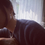 Bead pearl hoop earrings with a pearl necklace and ring on a person.