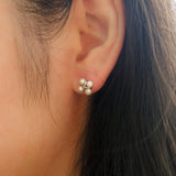 A close-up of a woman's ear wearing a four freshwater pearl rhomboid stud earring.