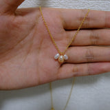 A gold chain necklace with three freshwater pearl pendants.