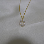 A gold-plated necklace with a pendant of five freshwater pearls arranged in a flower shape.