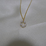 A gold-plated necklace with a pendant of five freshwater pearls arranged in a flower shape.