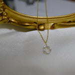 A gold-plated necklace with a pendant of five freshwater pearls arranged in a flower shape.