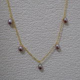 Dainty gold-plated necklace with five purple freshwater pearls.