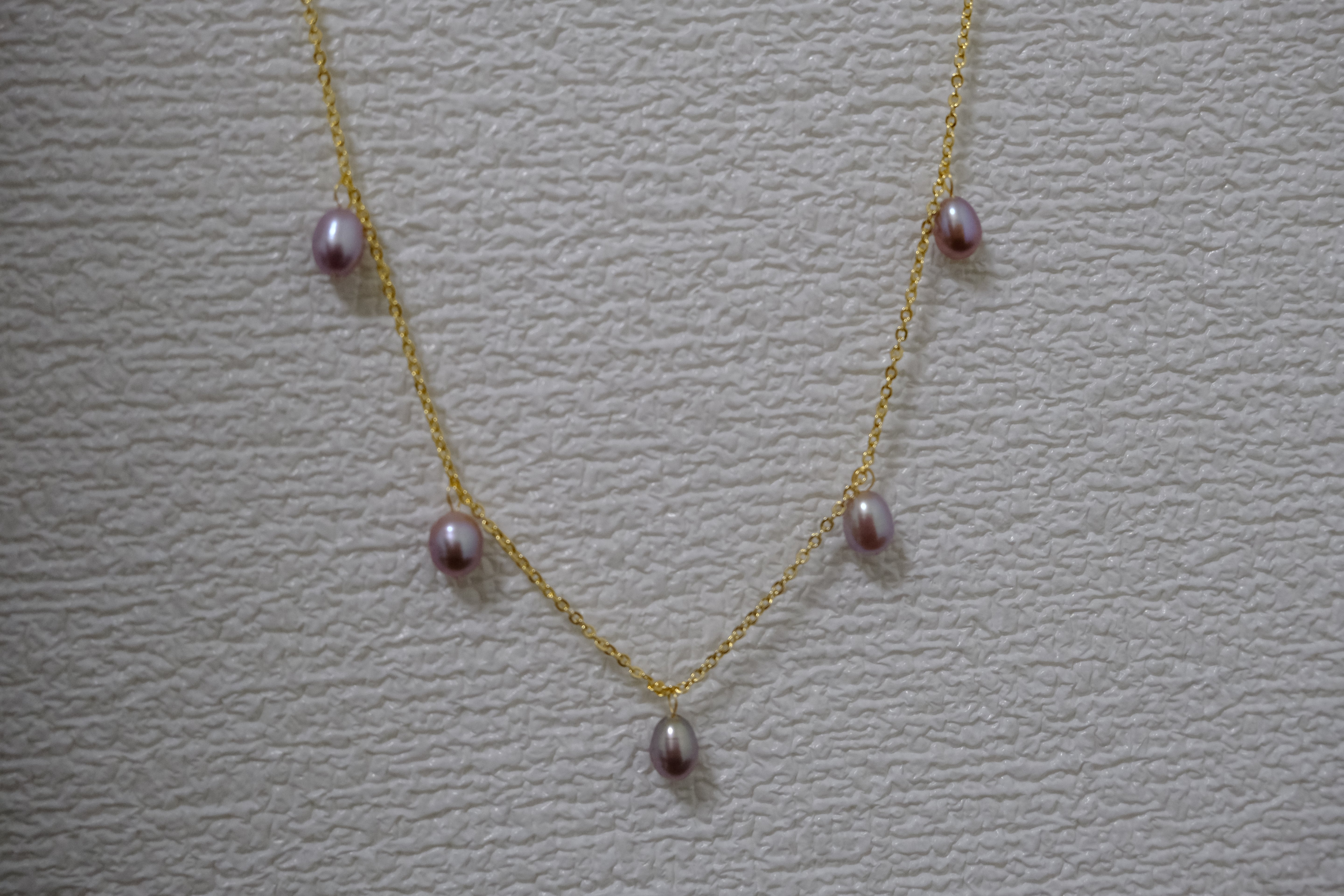 Dainty gold-plated necklace with five purple freshwater pearls.