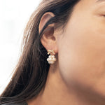 Gold-plated bowknot dangle freshwater pearl earring on a woman's ear.