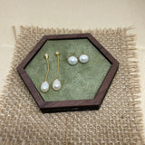Elegant pearl dangle earrings and pearl stud earrings in a hexagonal wooden box.