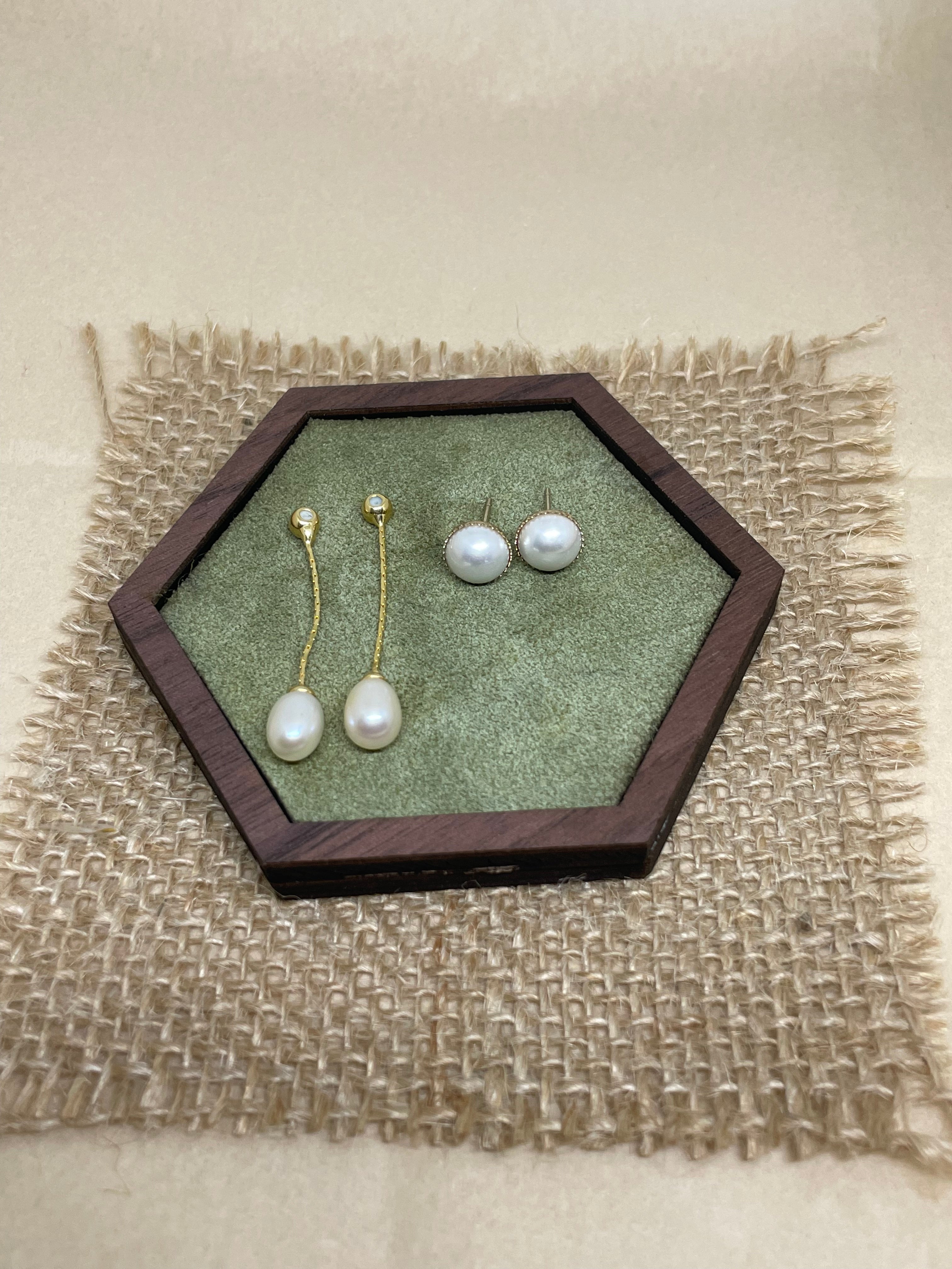 Elegant pearl dangle earrings and pearl stud earrings in a hexagonal wooden box.