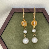 A pair of gold vintage-inspired drop earrings with two freshwater pearls each.