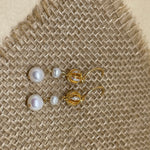 Two vintage freshwater pearl drop chain dangling earrings lie on a burlap surface.