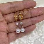 A pair of gold-toned drop earrings with two freshwater pearls each.