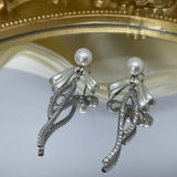 Elegant pearl bow dangle earrings with silver-plated chain and sparkling accents.
