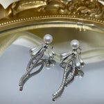 Elegant pearl bow dangle earrings with silver-plated chain.