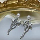 Elegant pearl bow dangle earrings with silver-plated chain.