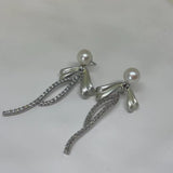 Elegant pearl bow dangle earrings with silver-plated chain and sparkling accents.