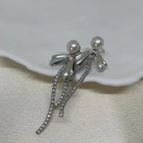 Elegant pearl bow dangle earrings with silver-plated chain and cubic zirconia.