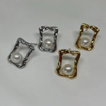 Four stud earrings, two gold and two silver, feature a pearl in a quadrate frame.