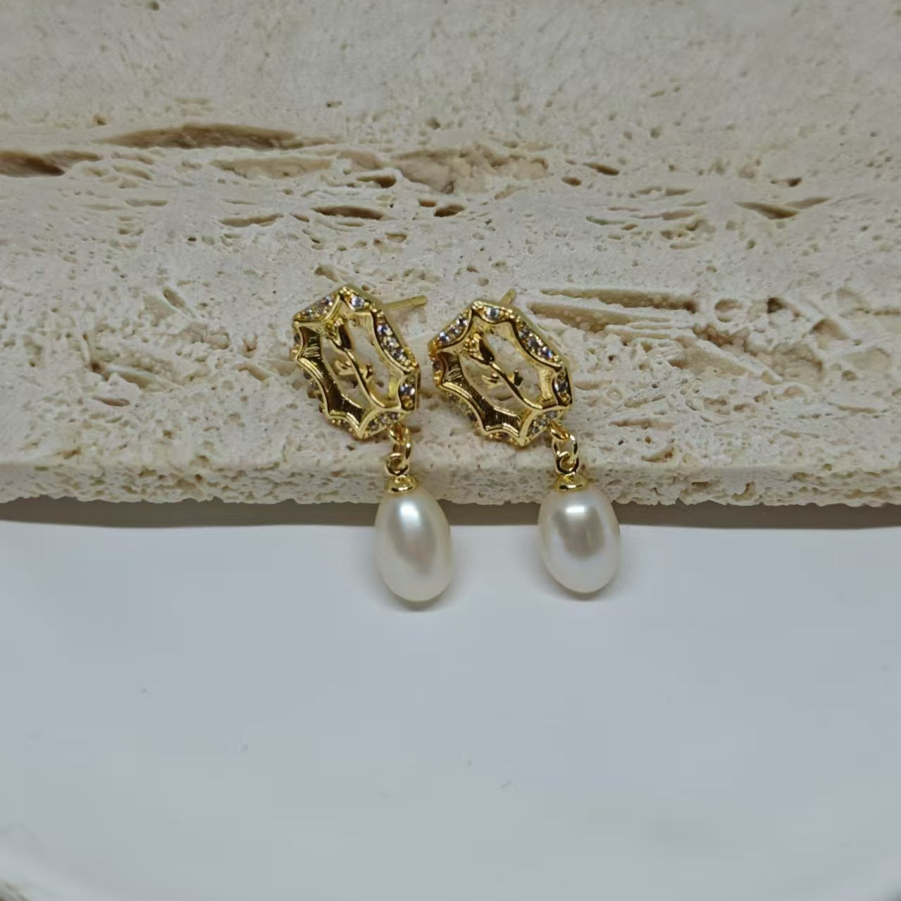Gold-plated earrings with a vintage design, featuring a rose and a dangling freshwater pearl.