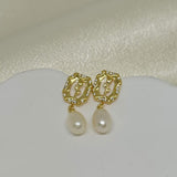 Gold-plated earrings with a rose design, clear stones, and dangling freshwater pearls.