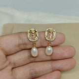 Gold-plated earrings with a rose design, surrounded by small gems, and a dangling pearl.