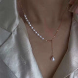 A gold-plated chain necklace with rice-shaped pearls and a single drop pearl.