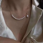 A rice-shaped pearl necklace with a gold-plated chain and a single drop pearl.