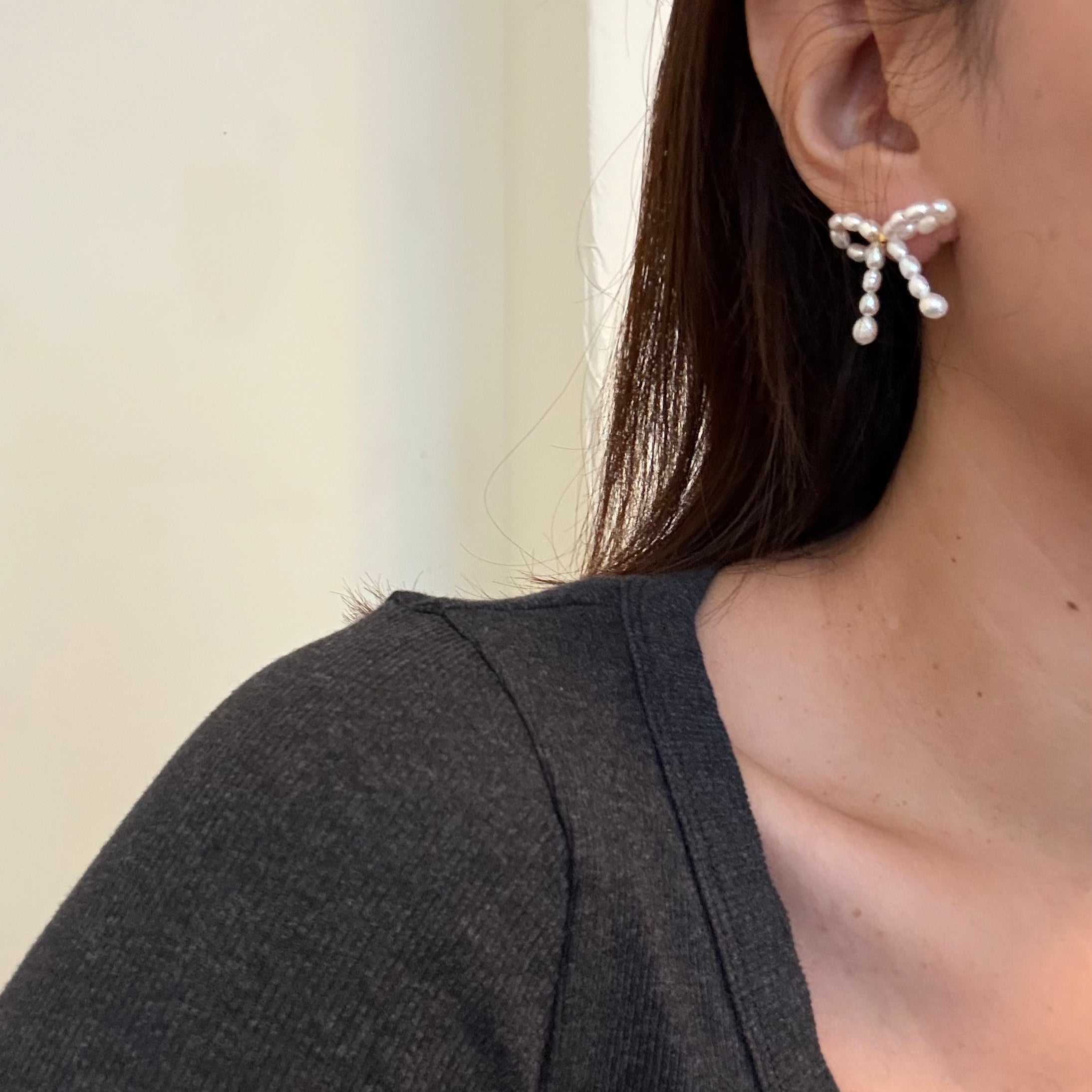 Pearl bow stud earrings with a delicate design.