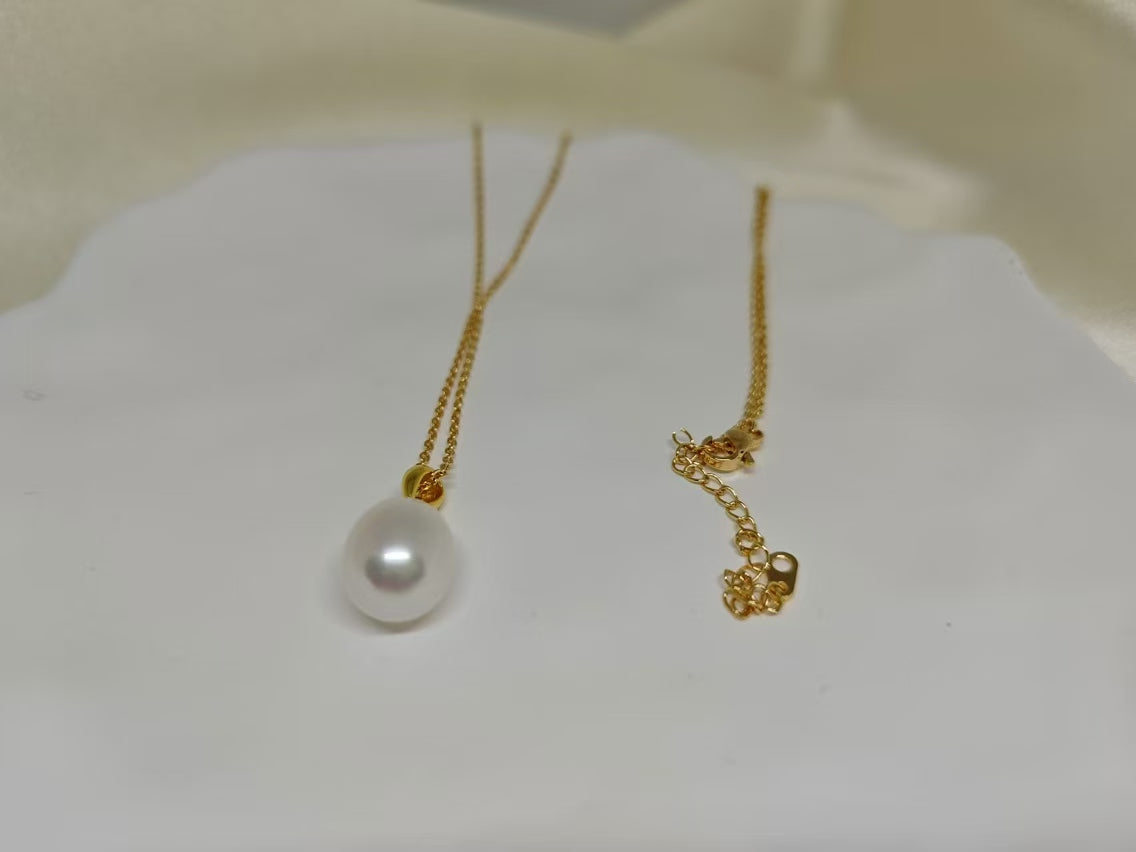 A gold chain necklace with an off-round white freshwater pearl pendant.