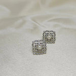 Silver quadrate stud earrings with a central pearl surrounded by small diamonds.