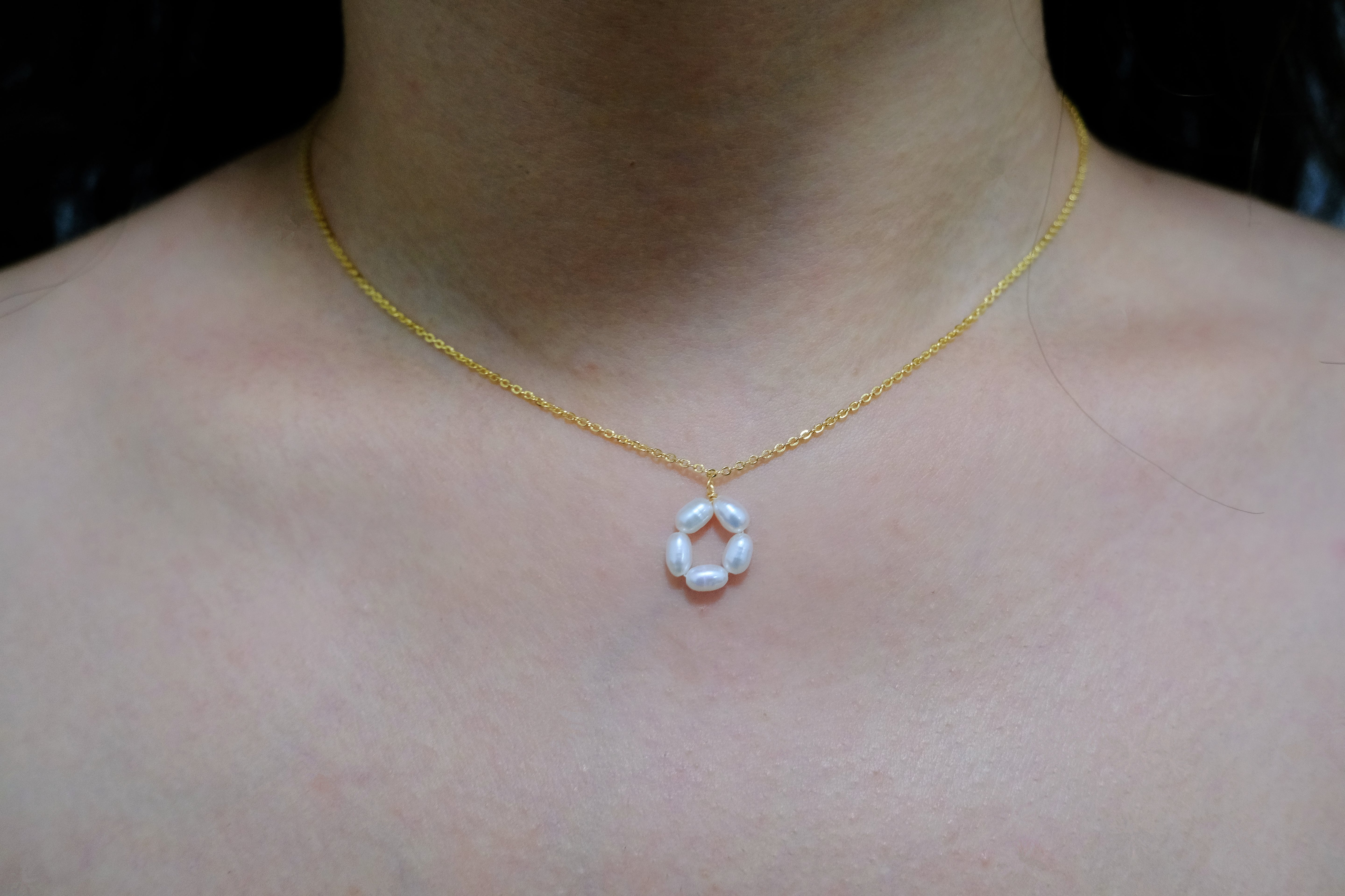Gold-plated necklace with a pendant of five freshwater pearls arranged in a flower shape.