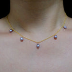Dainty gold-plated necklace with six purple freshwater pearls.