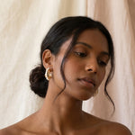 A model wears Caellia 14K gold bead hoop earrings accented with white freshwater pearls.