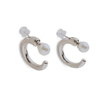 Two silver hoop earrings with a white pearl on each, secured by a clear backing.