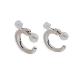 Two silver hoop earrings with a white pearl on each, secured by a clear backing.