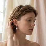 A woman wearing Caellia 14K gold plated silver double freshwater pearl teardrop earrings.
