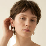 A model wears Caellia 14K gold plated silver double freshwater pearl teardrop earrings.