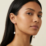 A model wears Caellia 14K gold plated sterling silver freshwater pearl drop chain earrings.