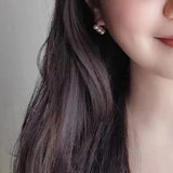 A woman wearing Caellia 14K gold plated freshwater pearl drop earrings.