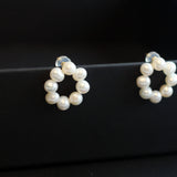 Pair of freshwater pearl circle stud earrings on black, showing natural pearl shape and luster