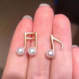 Caellia asymmetrical music note earrings crafted in 14K gold with freshwater pearls.