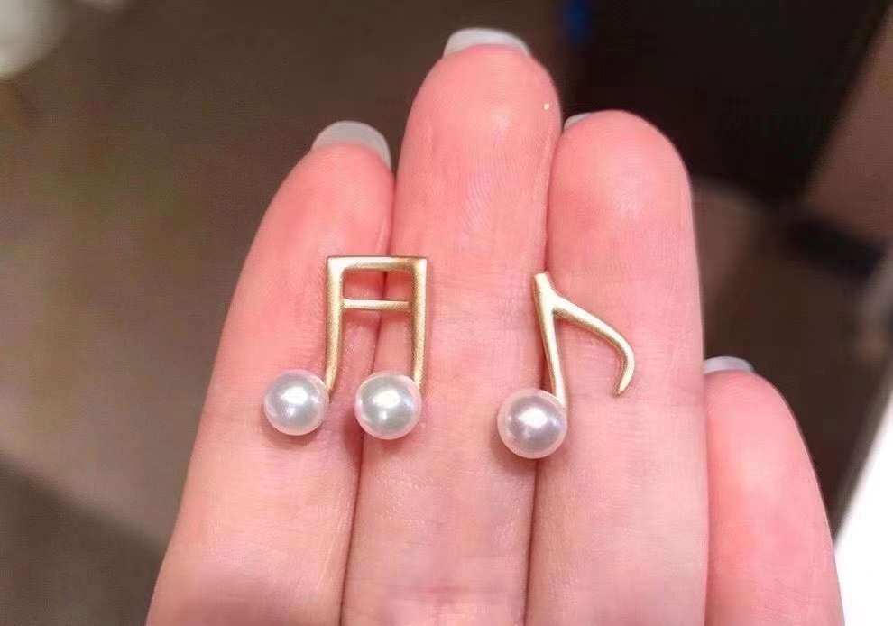 Caellia asymmetrical music note earrings crafted in 14K gold with freshwater pearls.