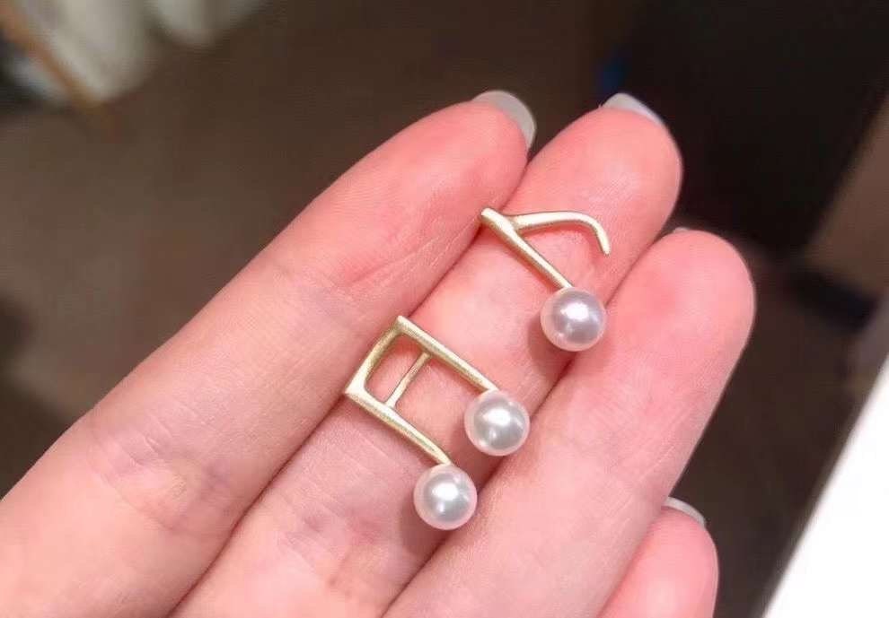 Caellia asymmetrical music note earrings crafted in 14K gold with freshwater pearls.