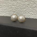 CAELLIA gold-plated stud earrings featuring lustrous round pearls with a delicate textured rim.