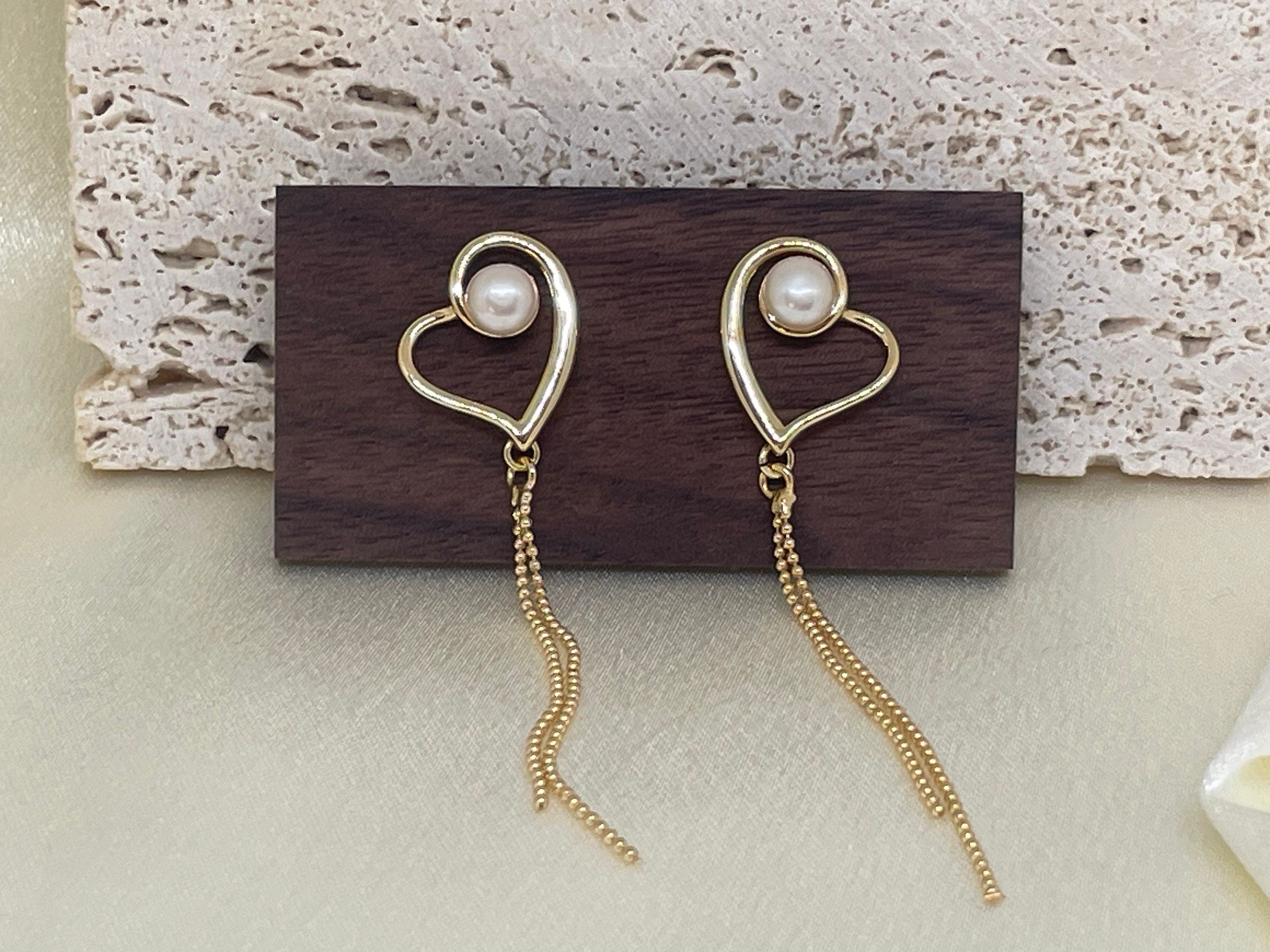 CAELLIA heart-shaped 18k gold plated dangle earrings featuring a pearl and delicate gold chains.