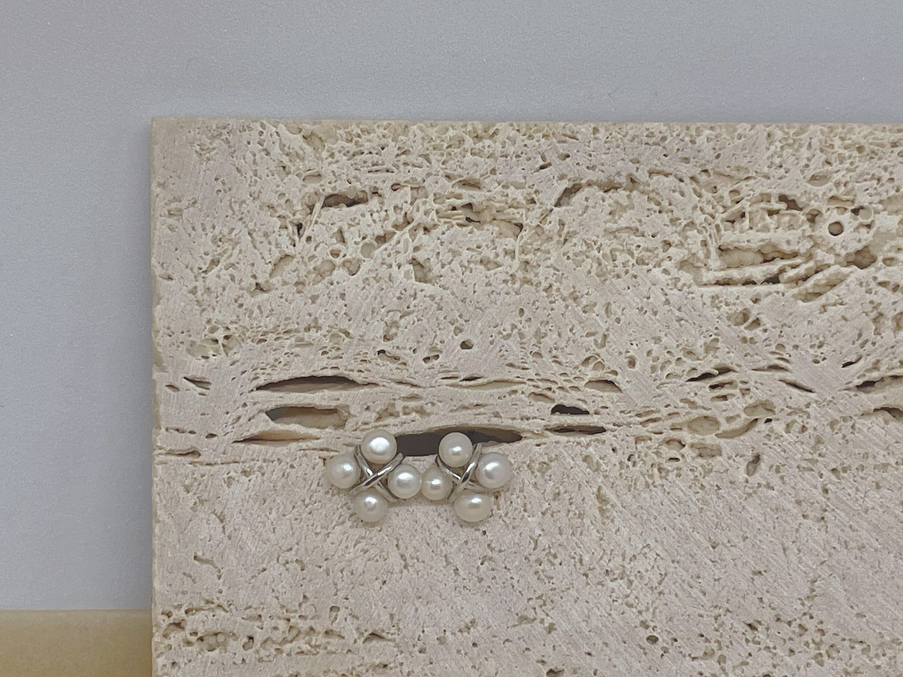 CAELLIA freshwater pearl rhomboid stud earrings featuring a four-pearl design on a stone background.