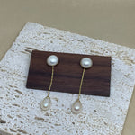 CAELLIA gold-plated dangle earrings featuring a round pearl stud and a teardrop pearl drop.