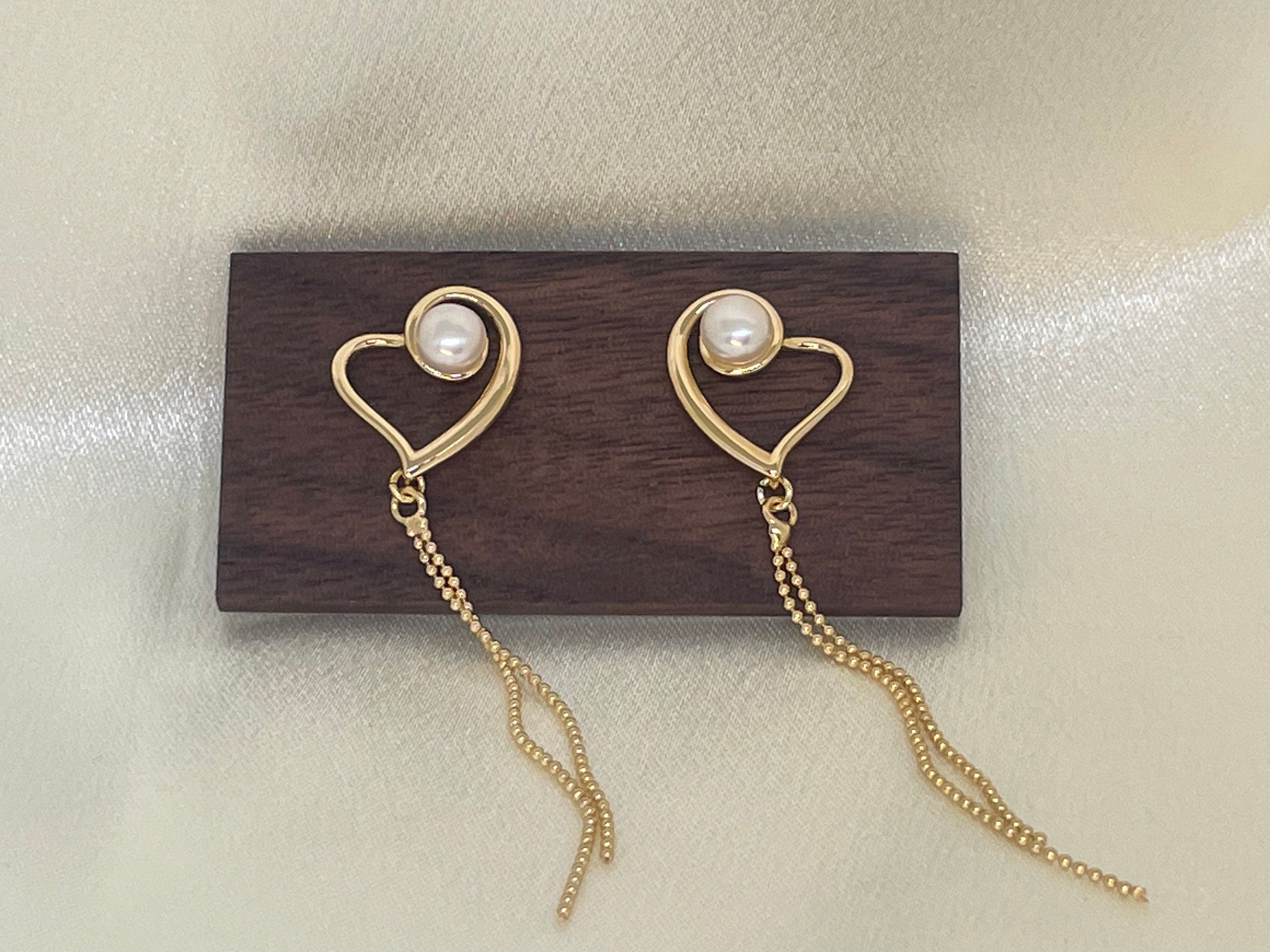 CAELLIA heart-shaped 18k gold plated dangle earrings featuring a pearl and delicate gold chains.
