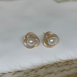 CAELLIA stud earrings featuring a central freshwater pearl surrounded by a gold-rimmed flower design.