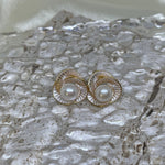 CAELLIA Camellia flower stud earrings featuring a central freshwater pearl in a gold trifoil design.