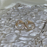 CAELLIA Camellia flower stud earrings featuring a central freshwater pearl in a gold trifoil design.